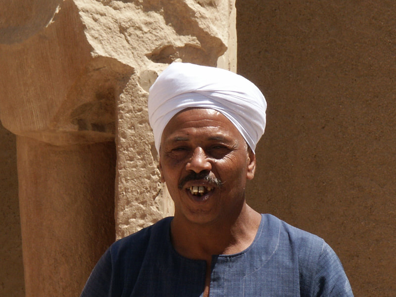 Lachender Fellache mit weissem Turban vor einer antiken Säule in Luxor