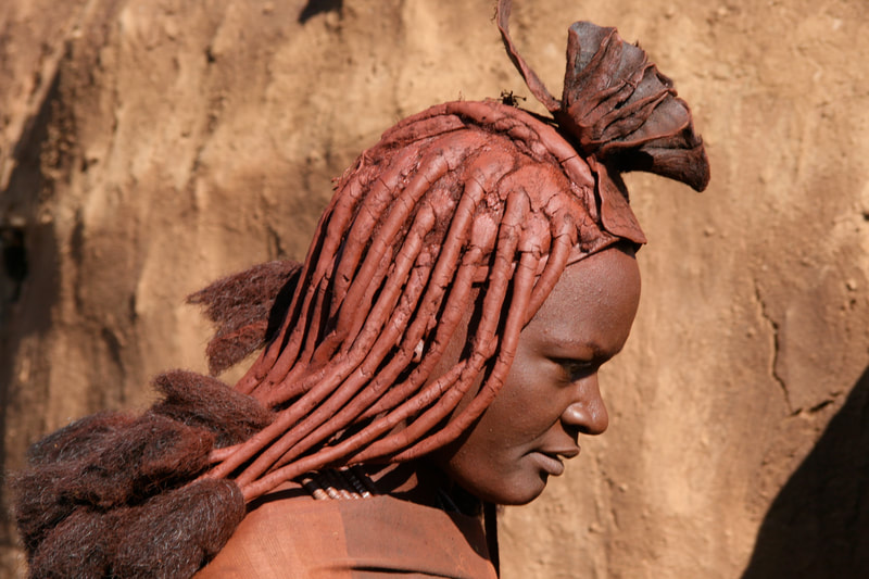 Himbafrau mit ockerfarbenen Zöpfen und ledernem Kopfputz im Kaoko-Land, Namibia
