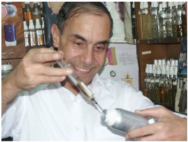 Nahaufnahme des Parfumeurs beim Mischen eines Duftes